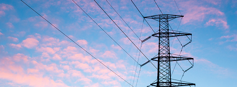 National Grid powerlines crossing a pink and blue sunset